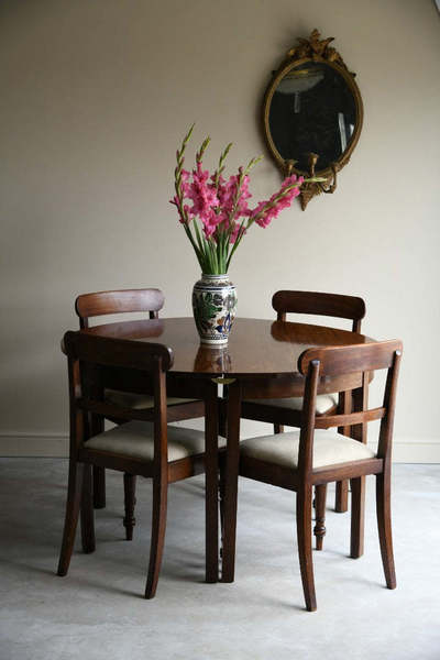 Mahogany Tables and Dining chairs dressed with flowers in a neutral room.