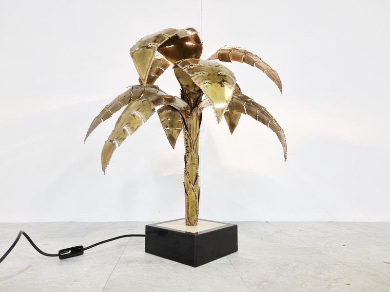 A brass table lamp shaped like a palm tree.