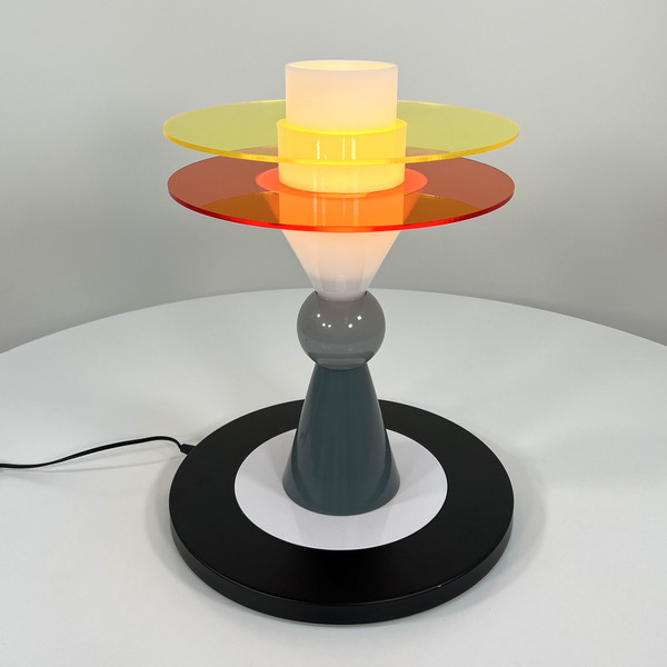 A post-modern table lamp with orange and yellow ringed lampshade