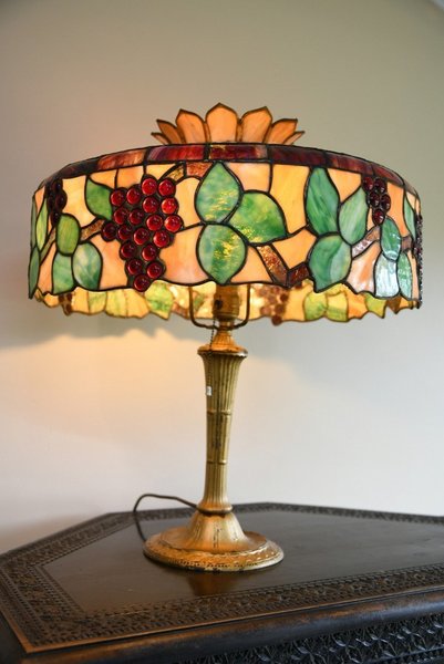 A Tiffany lamp with a grape-vine motif stained-glass lampshade.