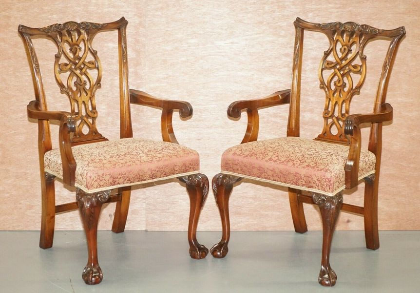A pair of claw and ball foot Thomas Chippendale dining chairs with armrests