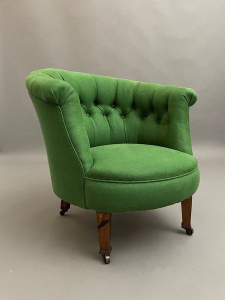 A button-tufted tub chair upholstered in bright green velvet
