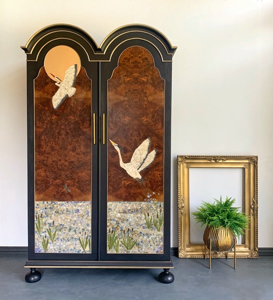 A scalloped-top walnut-burr armoire with Japanese-style crane art.
